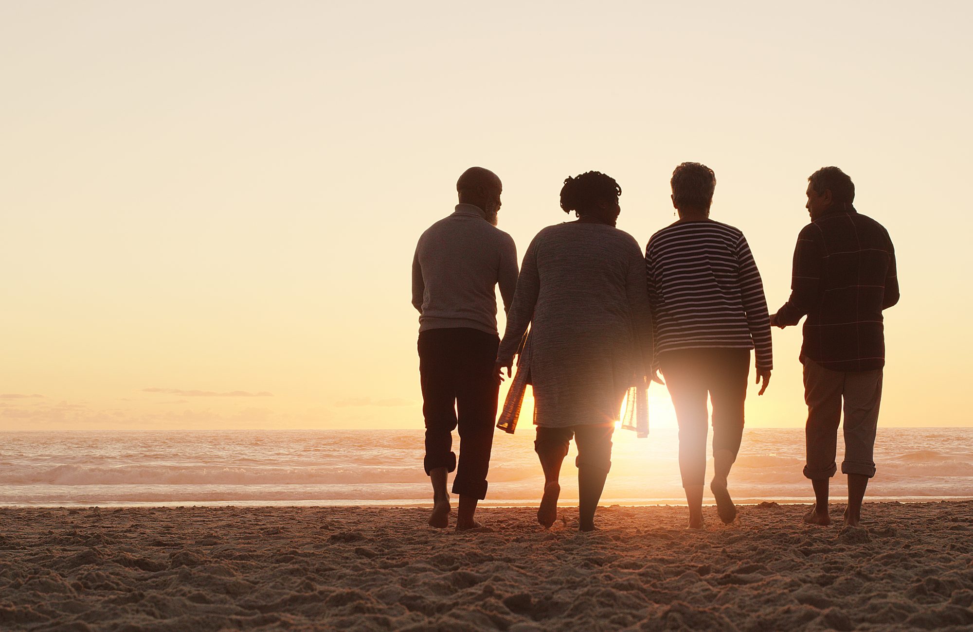 Full length shot of a group of friends enjoying a day out and walking along the beach together